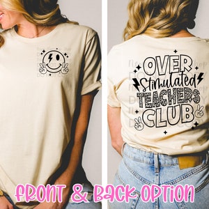 May include: A beige t-shirt with a black smiley face with a lightning bolt on the front and the text "Over Stimulated Teachers Club" with a leopard print design on the back.