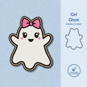 K&ouml;nnte beinhalten: Ein wei&szlig;er Geister-Ausstecher mit einer rosa Schleife, einem l&auml;chelnden Gesicht und gro&szlig;en Augen. Der Ausstecher ist schwarz umrandet und hat einen kleinen Rouge auf jeder Wange. Der Text "Girl Ghost Cookie Cutter" ist in der oberen rechten Ecke des Bildes sichtbar.