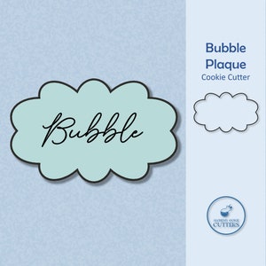 May include: A blue cookie cutter shaped like a cloud with the word "Bubble" written in black cursive. The cutter is shown on a light blue background with the text "Bubble Plaque Cookie Cutter" in black text.