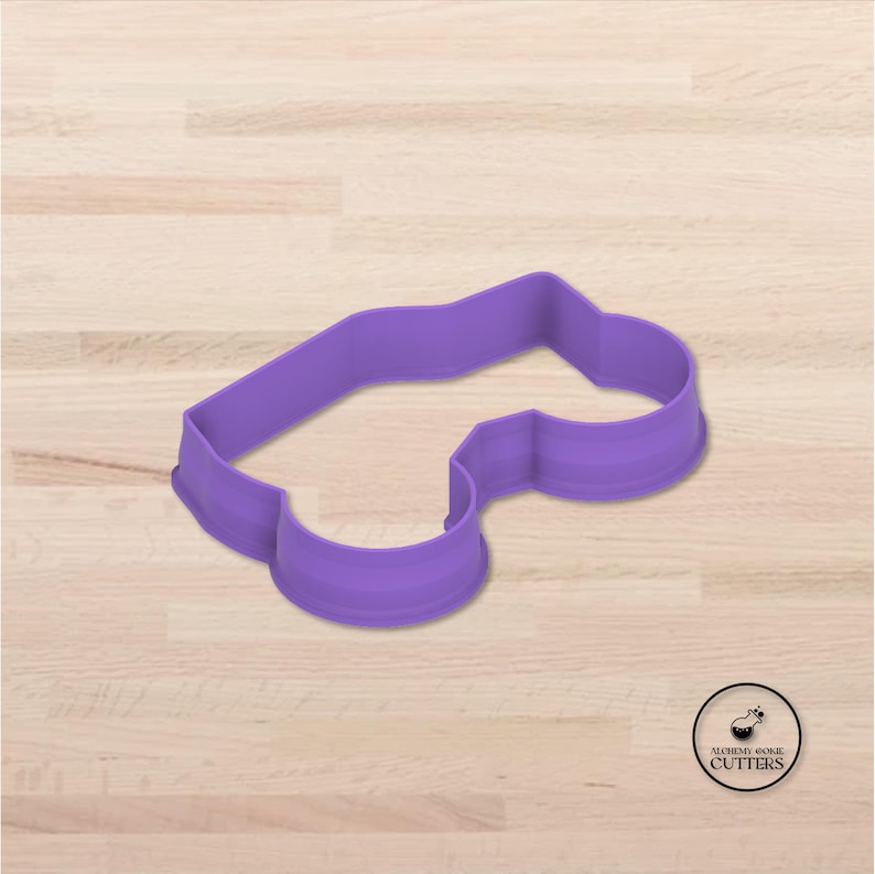 May include: A purple cookie cutter in the shape of a car. The cutter is made of plastic and has a smooth, rounded design. The Alchemy Cookie Cutters logo is in the bottom right corner.