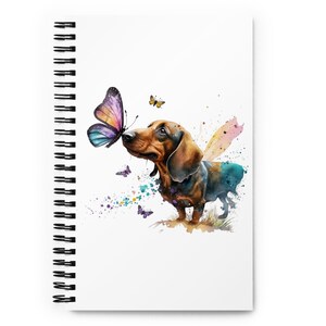 May include: A watercolor illustration of a dachshund dog with brown and black fur looking at a purple butterfly. The background is a white canvas with colorful watercolor splatters.