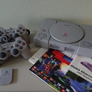 Console da gioco vintage Play Station 1 con scatola + 2 controller + cavi + manuali + 4 giochi + scheda di memoria
