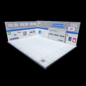 May include: A model garage diorama with a white floor and gray brick walls. The walls are decorated with Mopar logos and other automotive-themed graphics. A gray garage door with the word "Mopar" on it is visible in the background. The words "Mopar Hi-Performance" are printed on the wall above the garage door.