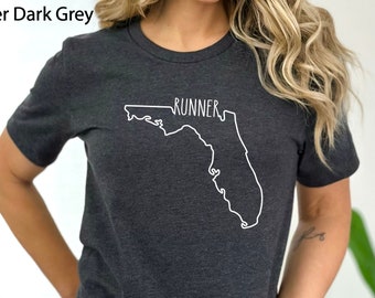 May include: A dark grey t-shirt with a white outline of the state of Florida and the word "RUNNER" inside the outline.