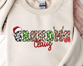 Puede incluir: Sudadera color arena con la frase "Grandma Claus" en un diseño festivo. Las letras están decoradas con patrones de cuadros, un gorro de Papá Noel, cuernos de reno y un suéter. La palabra "Claus" está en escritura roja.