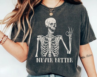 May include: A dark gray t-shirt with a skeleton graphic and the text "NEVER BETTER".
