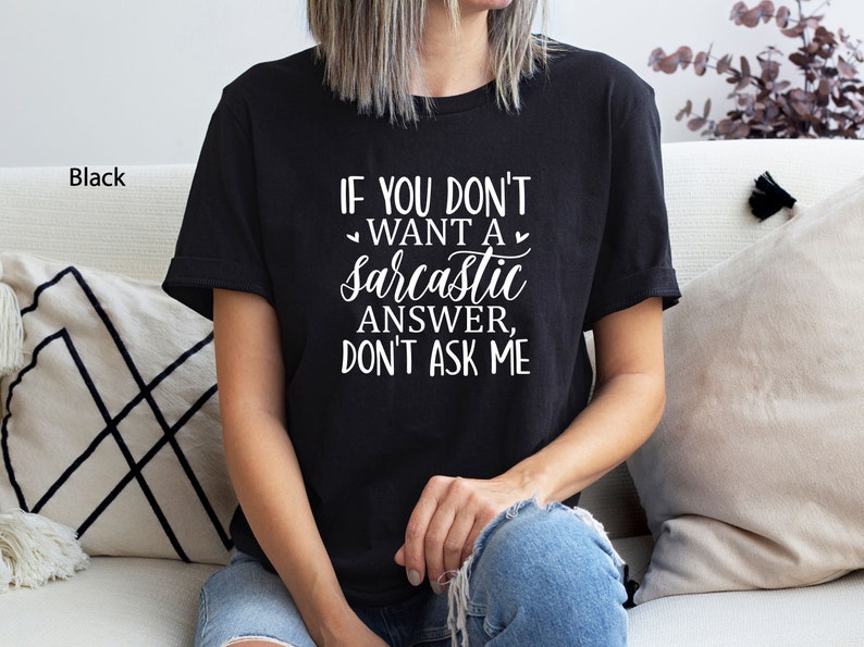 May include: A black t-shirt with white text that reads "If you don't want a sarcastic answer, don't ask me."