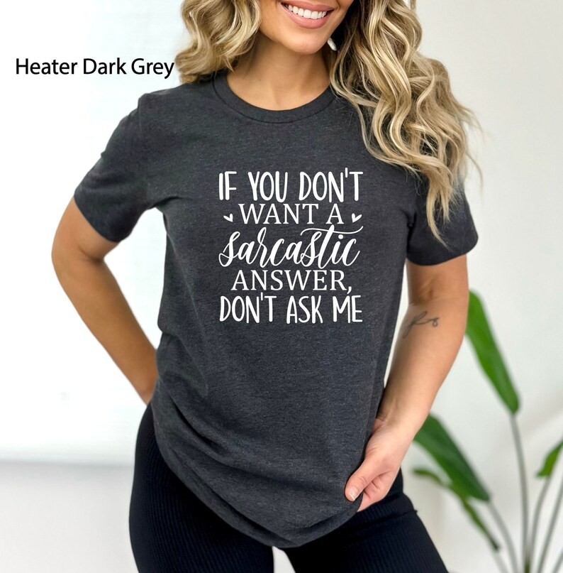 May include: A dark grey t-shirt with the text "If you don't want a sarcastic answer, don't ask me" printed in white.