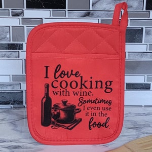 May include: Red quilted oven mitt with a black graphic that says "I love cooking with wine. Sometimes I even use it in the food."