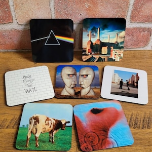 Juego de 5 o 7 posavasos con portadas de álbumes icónicos de Pink Floyd. Incluye Dark Side of Moon, The Wall, Meddle, Animals y Wish You Were Here.