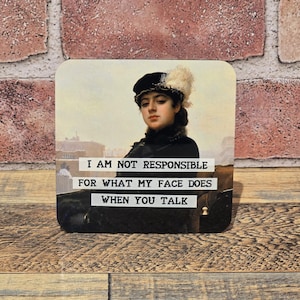 May include: Square coaster featuring a vintage portrait of a woman in a black hat with a white feather. The coaster has the text "I AM NOT RESPONSIBLE FOR WHAT MY FACE DOES WHEN YOU TALK" in white letters.