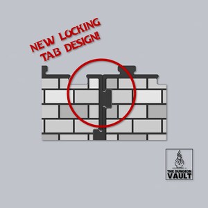 Peut inclure: Deux panneaux muraux en briques grises, avec un nouveau design de languette de verrouillage, mis en &eacute;vidence par un cercle rouge. Le texte "NEW LOCKING TAB DESIGN!" est en rouge. Le logo The Dungeon Vault est en bas &agrave; droite.