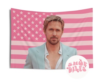 Op de afbeelding: Roze wandtapijt met een portret van een man in een lichtblauw pak tegen een roze Amerikaanse vlag. Een cirkelvormig logo met de tekst "SHOP DILFS" staat in de rechter benedenhoek.