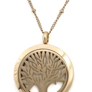 May include: A gold-toned necklace with a round pendant featuring a tree of life design. The pendant has a small opening on the side for adding essential oils.