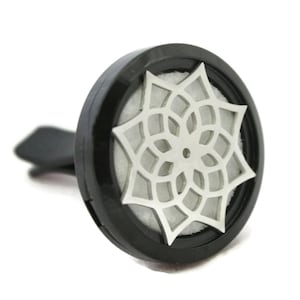 May include: Black car air freshener with a silver mandala design. The air freshener is designed to hold essential oils or fragrance pads.