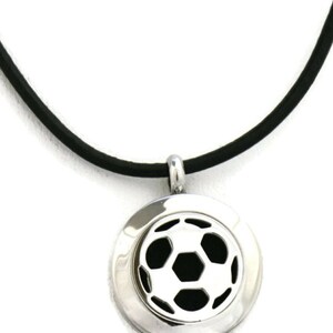 May include: A silver pendant necklace with a black soccer ball design. The necklace is on a black leather cord.