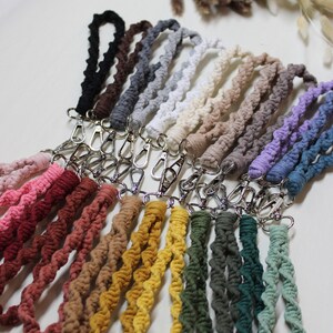 May include: A collection of 18 colorful crocheted cords with silver clasps. The cords are arranged in a rainbow pattern, with the darkest colors at the top and the lightest colors at the bottom.