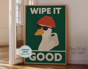 May include: Framed digital print wall art. A cartoon duck in sunglasses and a red hat holds a toilet roll. The words "WIPE IT GOOD" are printed in white on a dark green background. A fun, quirky piece of wall art.