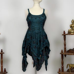 May include: Teal dress with a corset bodice and spaghetti straps. The dress has detailed embroidery and an asymmetrical hem. The dress is displayed on a mannequin. The dress is approximately 90 cm in length.