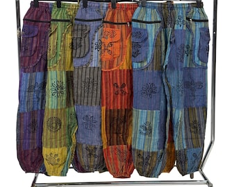 May include: A variety of colorful patchwork pants hanging on a metal rack. Each pair features a unique combination of colors and patterns, including stripes, floral designs, and pockets. The pants are made of a lightweight fabric, perfect for casual wear.