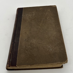 May include: A brown book with a dark brown spine. The title on the cover reads "Plan of the City of New York".