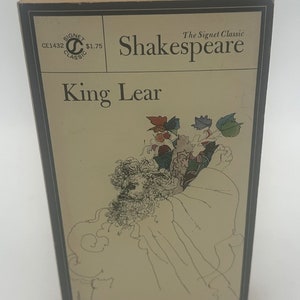 Puede incluir: Un libro de bolsillo Signet Classic con una cubierta marrón y una ilustración en blanco y negro de King Lear. El título "King Lear" está impreso en texto negro en la portada. El libro es una edición Signet Classic de la obra de Shakespeare King Lear.