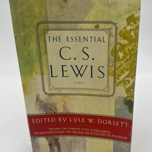 May include: A book cover with a yellow and green background. The title is "The Essential C.S. Lewis" in black text. The subtitle is "Edited by Lyle W. Dorsett" in red text. The book includes the complete texts of "Perelandra", "The Abolition of Man", and "The Lion, the Witch and the Wardrobe".