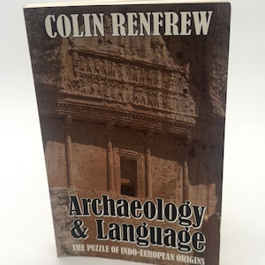 May include: A book titled "Archaeology & Language: The Puzzle of Indo-European Origins" by Colin Renfrew. The cover features a photograph of an ancient stone structure with a doorway.
