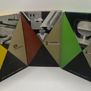 May include: Three vintage ALCOA handbooks with geometric designs. The covers feature a yellow, red, and green color scheme with black triangles. The books are titled "ALCOA Structural Handbook," "Forming Alcoa Aluminum," and "ALCOA Aluminum Handbook."