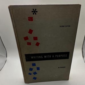 Pode incluir: Um livro vintage intitulado "Writing With a Purpose" de McCrimmon. A capa é verde suave com uma faixa preta contendo o título. Formas geométricas vermelhas e azuis e um asterisco preto decoram a capa. "Second Edition" é impresso no topo.