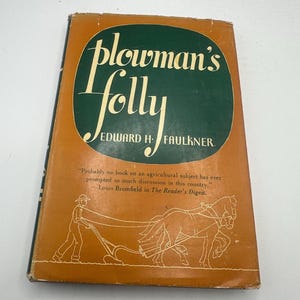 Może przedstawiać: Zabytkowa książka zatytułowana "Plowman's Folly" autorstwa Edwarda H. Faulknera. Okładka jest pomarańczowa z zielonym owalem zawierającym tytuł białą czcionką. Zawiera ilustrację rolnika orzącego z końmi.