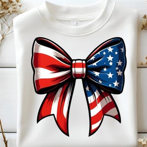 May include: White sweatshirt with a large bow design. The bow is a patriotic graphic with red and white stripes on one side and blue with white stars on the other, with a black outline.