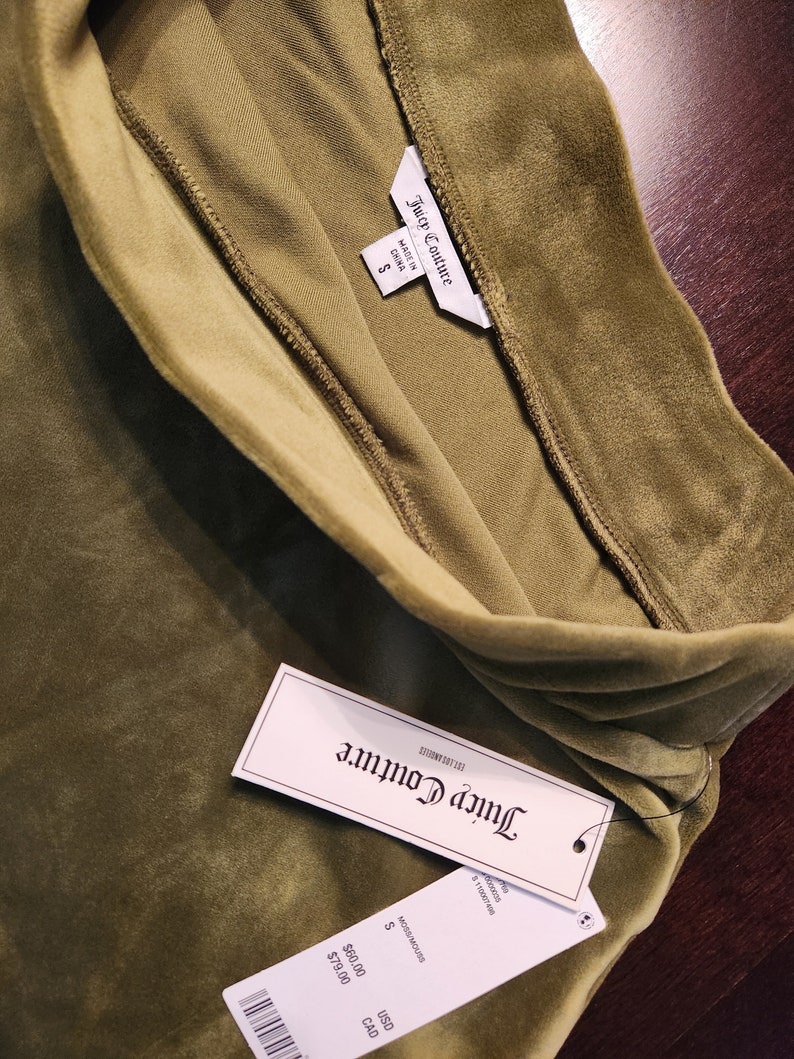 May include: A green velvet Juicy Couture top with a tag that says "Juicy Couture" and "Made in China". The tag also shows the size "S" and the price in USD and CAD.