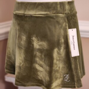 May include: A green velvet mini skirt with a Juicy Couture label and a rhinestone logo.