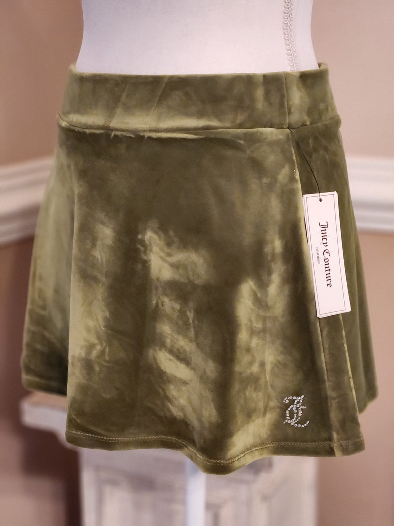 May include: A green velvet mini skirt with a Juicy Couture label and a rhinestone logo.