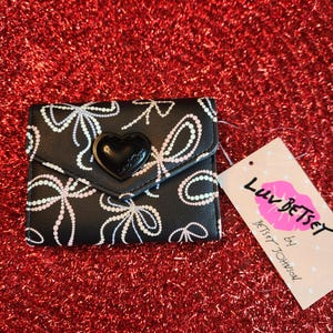 Cartera pequeña con detalle de logotipo de corazón negro y estampado de lazo de Betsey Johnson