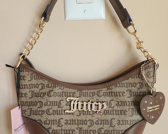 May include: A brown and tan hobo-style handbag featuring a repeating Juicy Couture logo pattern. The bag has a gold-tone chain and brown strap, a central gold-tone Juicy logo, and a heart-shaped charm with small crystals attached to the side.