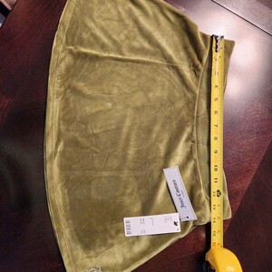 May include: A green velvet skirt with a Juicy Couture tag and a rhinestone logo. The skirt is 15 inches long.