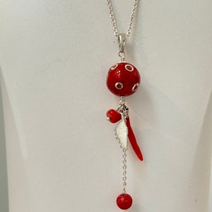 Collier argent pendentif perle corail incrustée d’argent et 3 breloques: carte de la corse, une amulette et une perle de corail rouge .