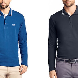 Puede incluir: Dos polos de manga larga, uno azul y otro azul marino, con cuello blanco y una raya blanca en el cuello. Ambas camisas tienen un pequeño logotipo en el pecho izquierdo que dice "BOSS".