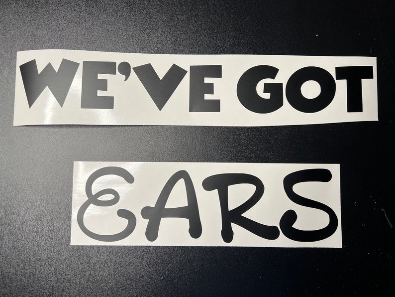 Pode incluir: Adesivo de vinil branco com letras pretas que diz "We've got ears".