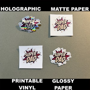 Op de afbeelding: Vier stickers met de tekst "Super Dad" in een comic-lettertype. De stickers worden getoond op vier verschillende oppervlakken: holografisch, mat papier, bedrukbaar vinyl en glanzend papier.