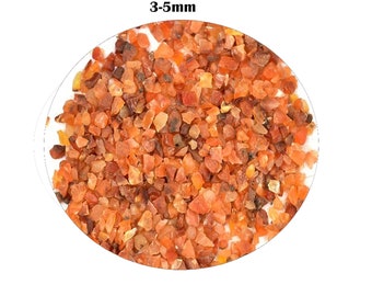 May include: A close-up image of a pile of small, red carnelian gemstone chips. The chips are approximately 3-5mm in size.