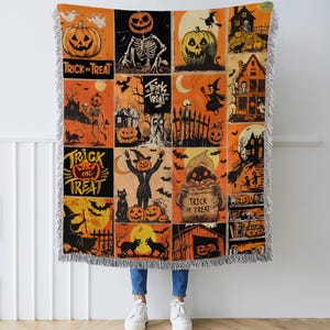 May include: A Halloween-themed throw blanket with a patchwork design. The blanket features orange, black, and cream-colored squares with various spooky illustrations, including pumpkins, skeletons, and haunted houses. The words "Trick or Treat" are also visible.