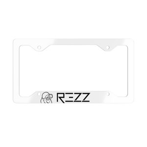 May include: White plastic license plate frame with black text that reads "REZZ" and a small black and white illustration of a person wearing a helmet and goggles.