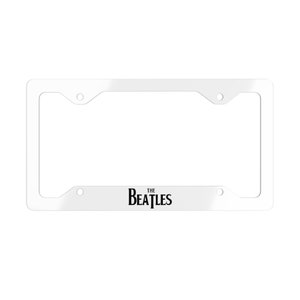May include: White metal license plate frame with the text "THE BEATLES" in black lettering.