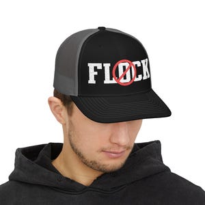 Peut inclure: Une casquette trucker noire et grise avec le texte brodé en blanc FLOCK, incluant un cercle rouge et une ligne diagonale traversant la lettre O. La casquette présente un panneau avant structuré, une visière plate et un panneau arrière en filet.