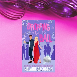 May include: Book cover with a purple background and a couple in front of a disco ball. The title is "Dropping the Ball" and the author is "Melanie Jacobson".