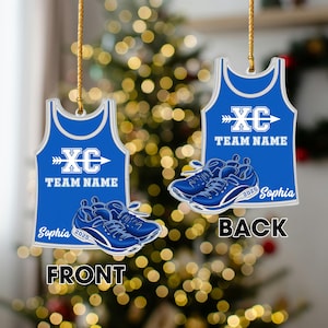 May include: Two blue and white cross country team ornaments. Each ornament is shaped like a tank top and features the text "XC TEAM NAME" and a pair of running shoes. The name "Sophia" and the year "2025" are also included.
