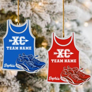 May include: Two athletic-themed ornaments. One is blue, the other red, each with a tank top design. The blue ornament has a white "XC" logo and "TEAM NAME" text, with a pair of blue running shoes. The red ornament has a similar design with red shoes.